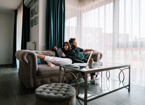 two expats sitting on a couch in a condo rental